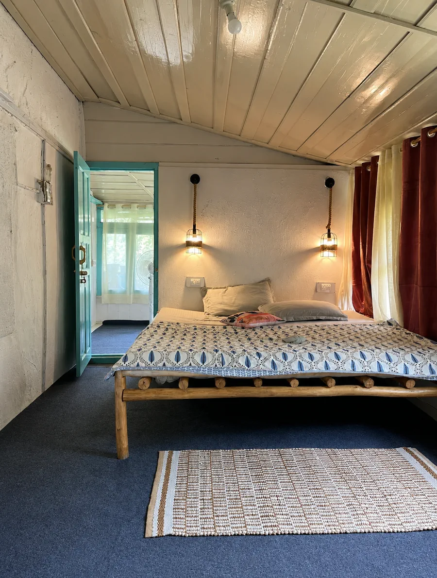 A warm bedroom with a patterned bedspread and teal doorway at The Nook