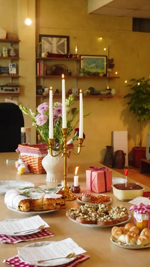 A candlelit table laid with bakes, breads and handmade plates at the studio