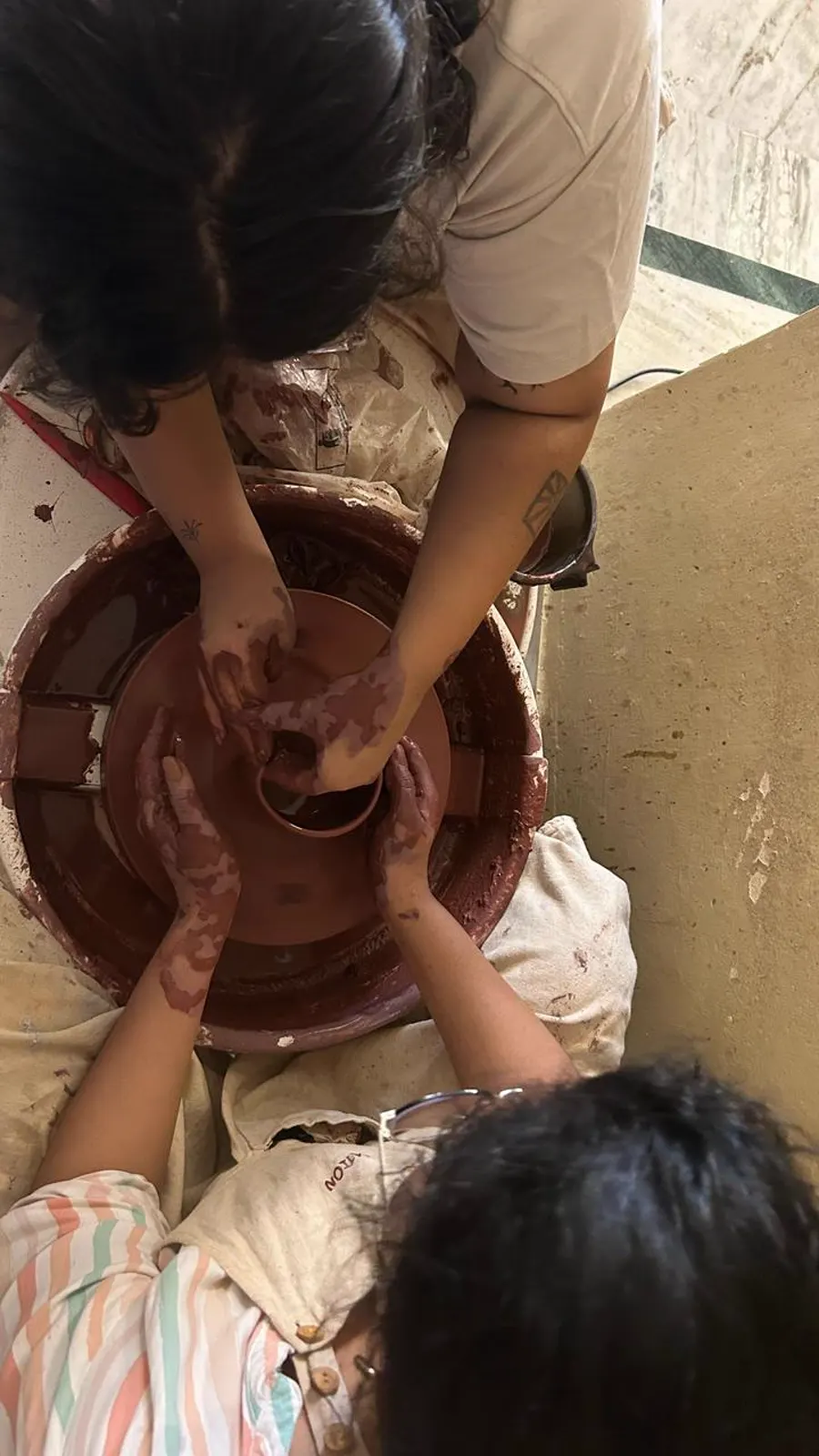 Four hands on the wheel together, learning to pull a bowl