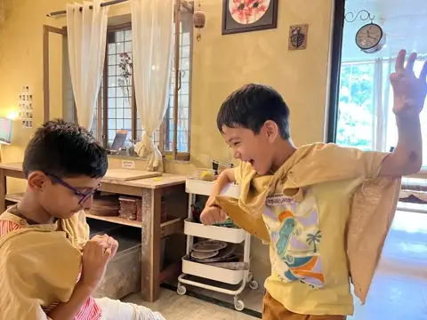 Two boys mid-laugh in the studio during Kids Club