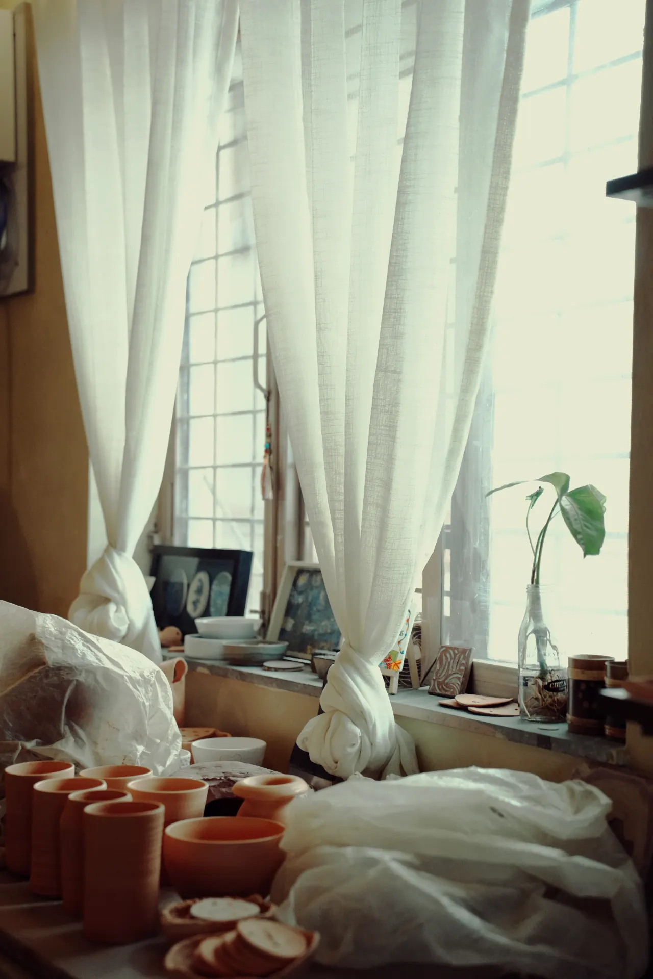 Sunlit interior of Lumière Bakestudio with shelves of handmade pottery