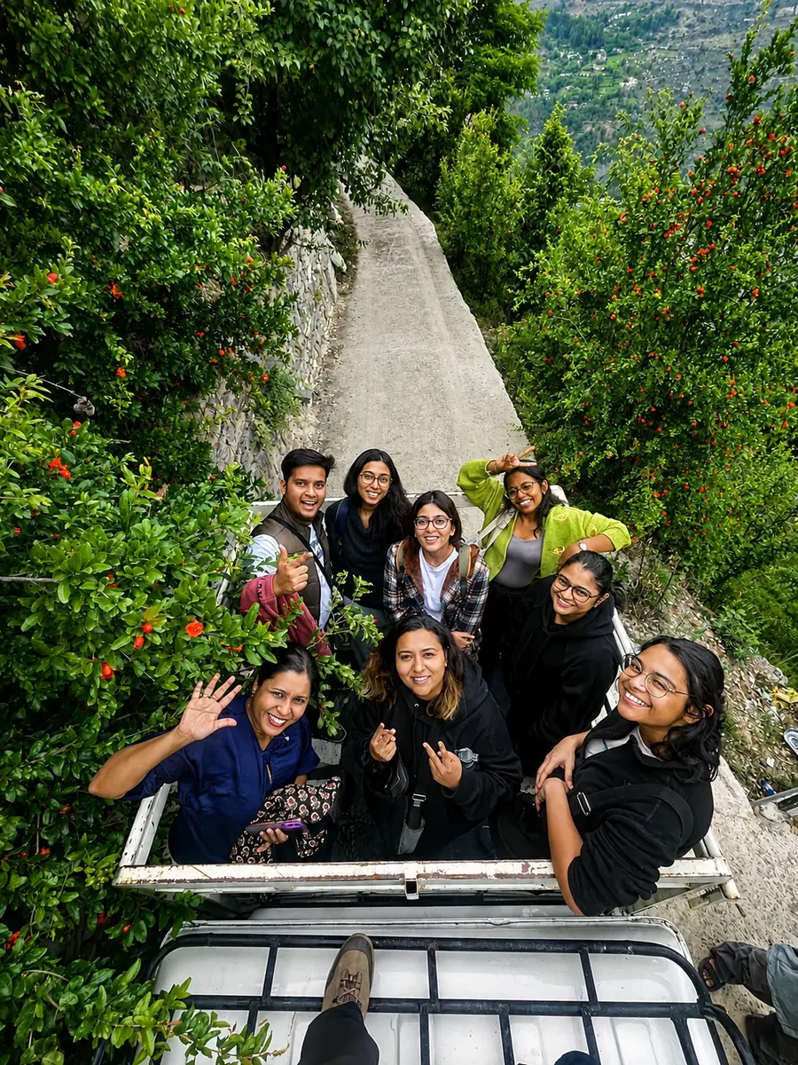 Retreat guests riding in the back of a jeep up the valley road, waving at the camera