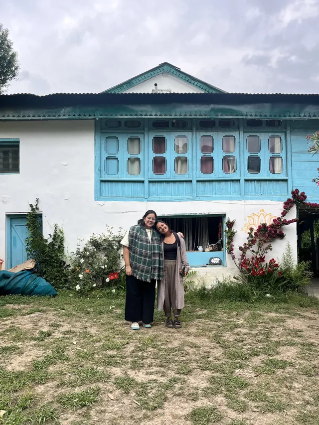 Two guests outside the blue-windowed Himachali house at The Nook