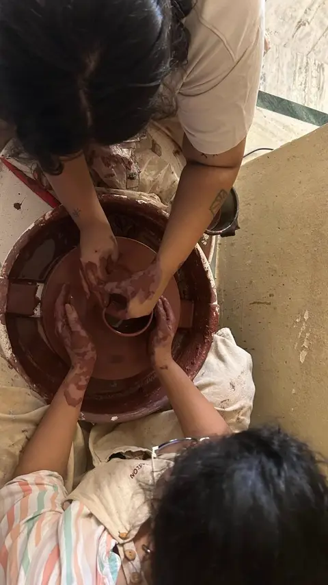 Four hands on the wheel together, learning to pull a bowl